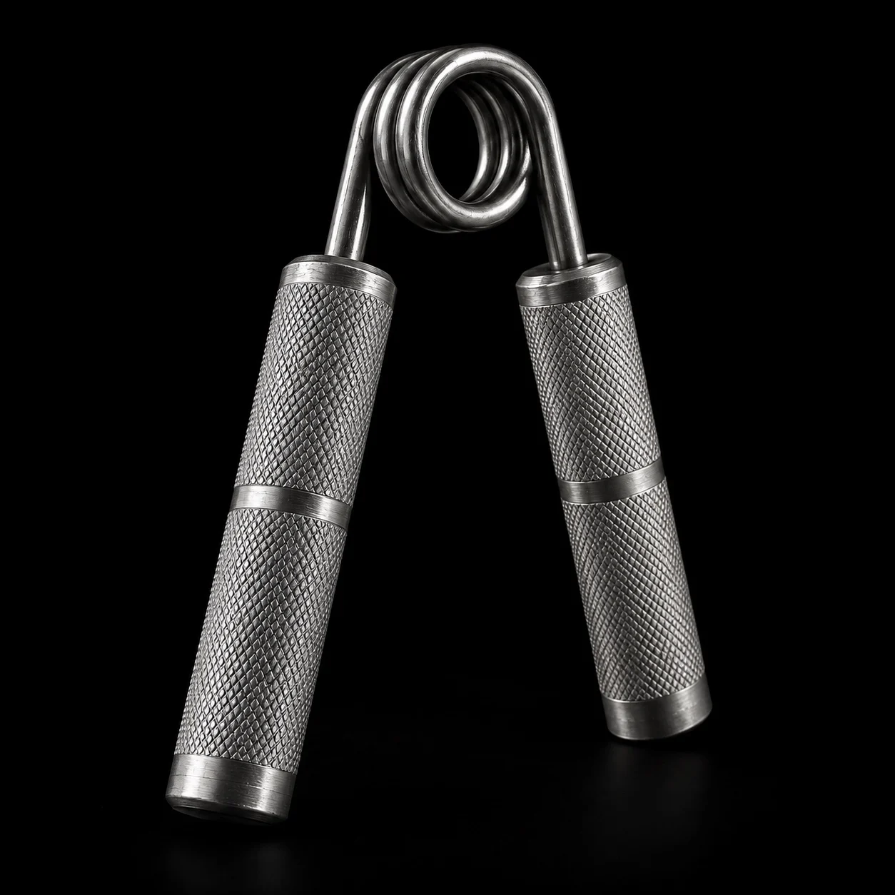 Sculptural close-up of an unbranded steel gripper concept: a polished spring and deeply textured handles